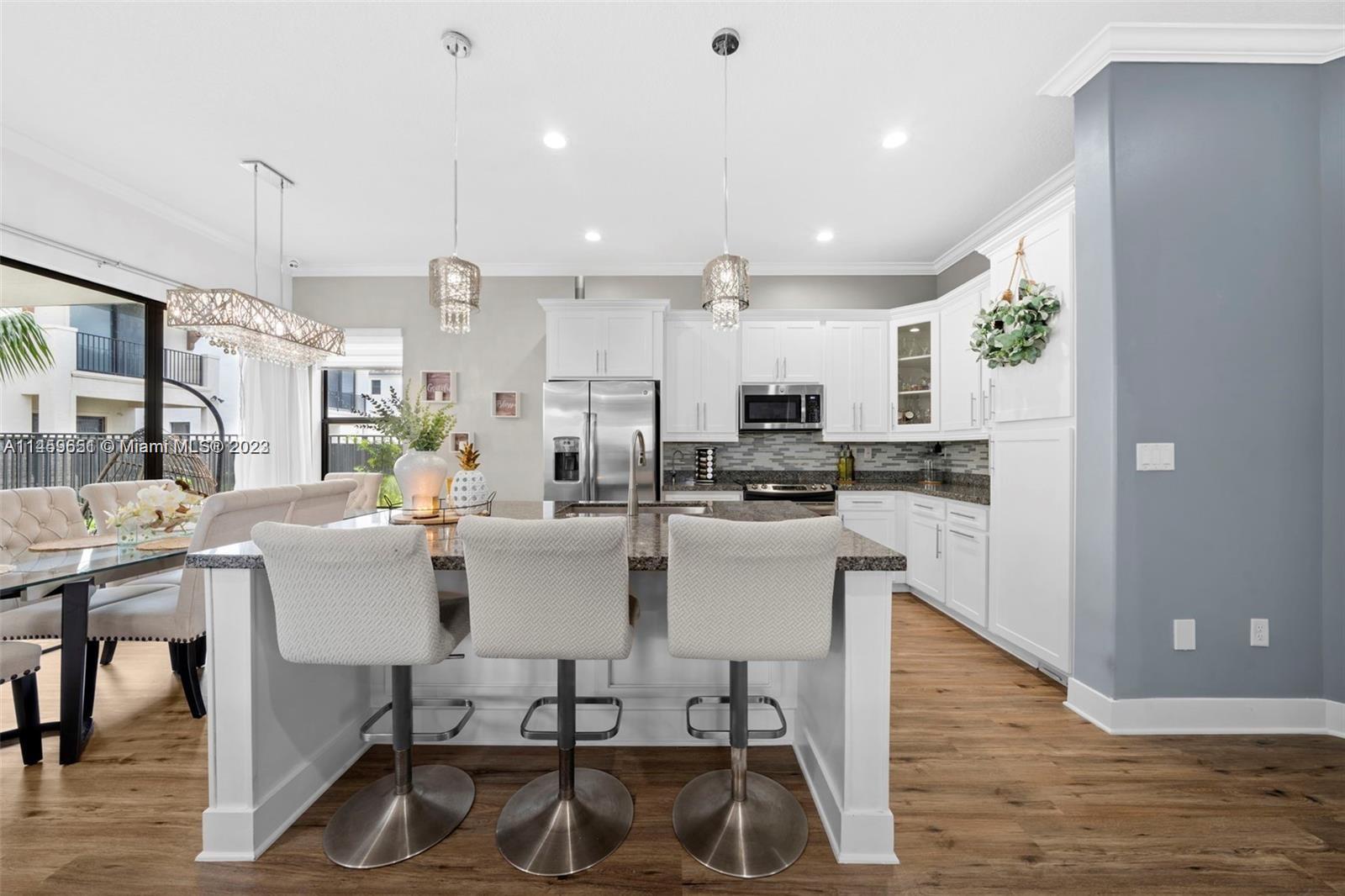 Hialeah Hialeah, FL 33018 - Photo 7 of 54 a kitchen with a dining table chairs sink and cabinets