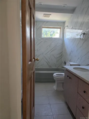 a bathroom with a granite countertop toilet a sink and bathtub