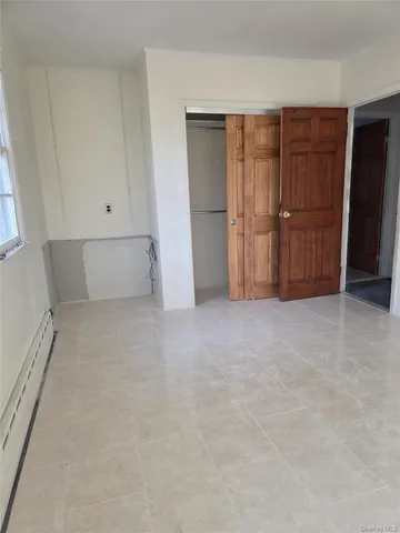 a view of an empty room with closet and cabinet
