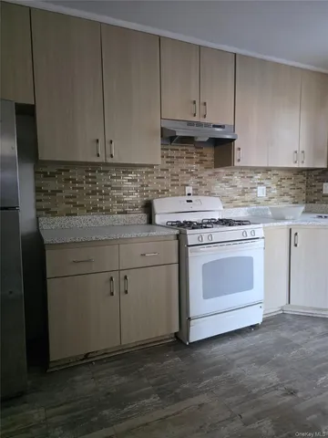 a kitchen with granite countertop white cabinets and white appliances