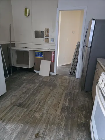 a view of kitchen with refrigerator stove and wooden floor