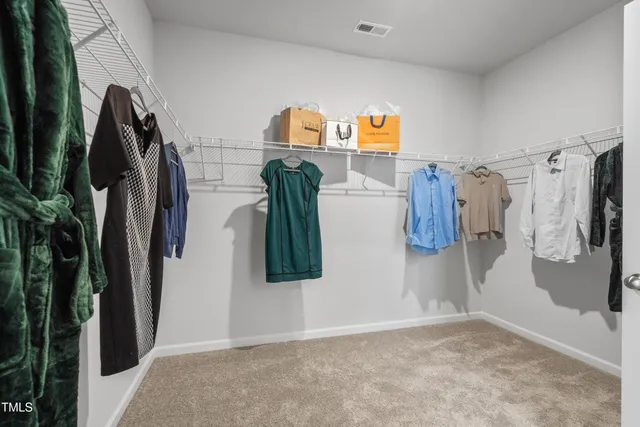 a view of walk in closet with clothes and shoes