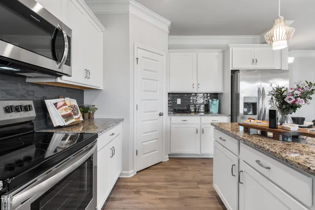 a kitchen with stainless steel appliances granite countertop a stove and cabinets