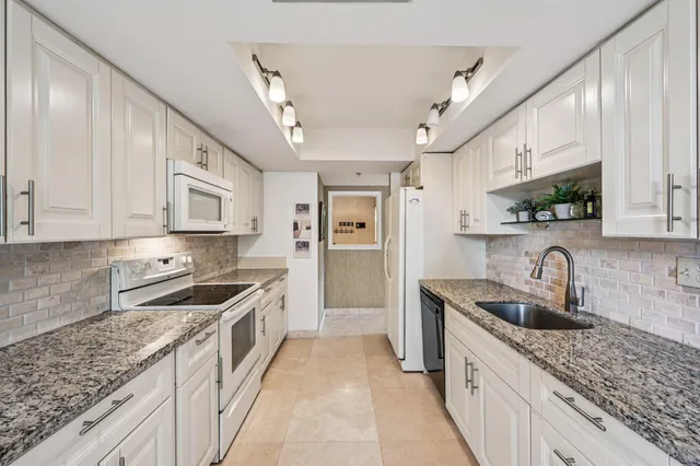 a kitchen with stainless steel appliances granite countertop a sink stove and cabinets