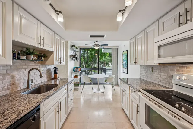 a kitchen with stainless steel appliances granite countertop a stove a sink dishwasher and cabinets with wooden floor