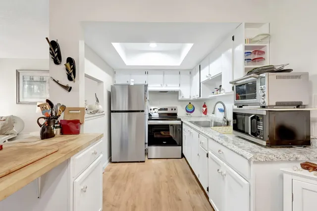 a kitchen with stainless steel appliances granite countertop a sink and a stove