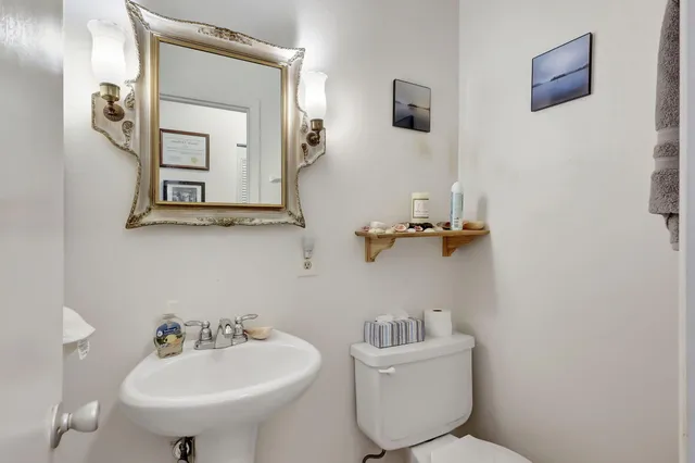 a bathroom with a toilet sink and mirror