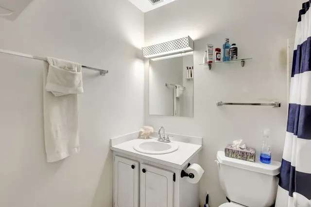 a bathroom with a sink toilet and a mirror