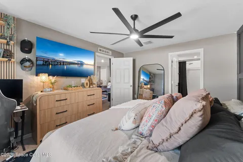 a bedroom with a bed and a mirror on the dresser