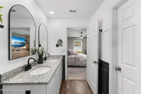 a en suite bathroom with a granite countertop sink and a mirror