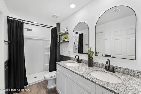 a bathroom with a granite countertop sink mirror vanity and toilet