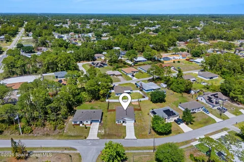 an aerial view of residential houses with outdoor space and street view