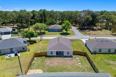an aerial view of a house with garden space and street view