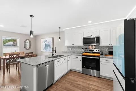 a kitchen with granite countertop a sink stove and cabinets