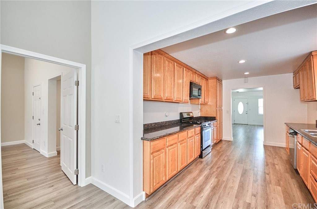 18319 Norwalk Boulevard Artesia, CA 90701 - Photo 16 of 39 a large kitchen with granite countertop a large counter top space a sink a stove and wooden floor
