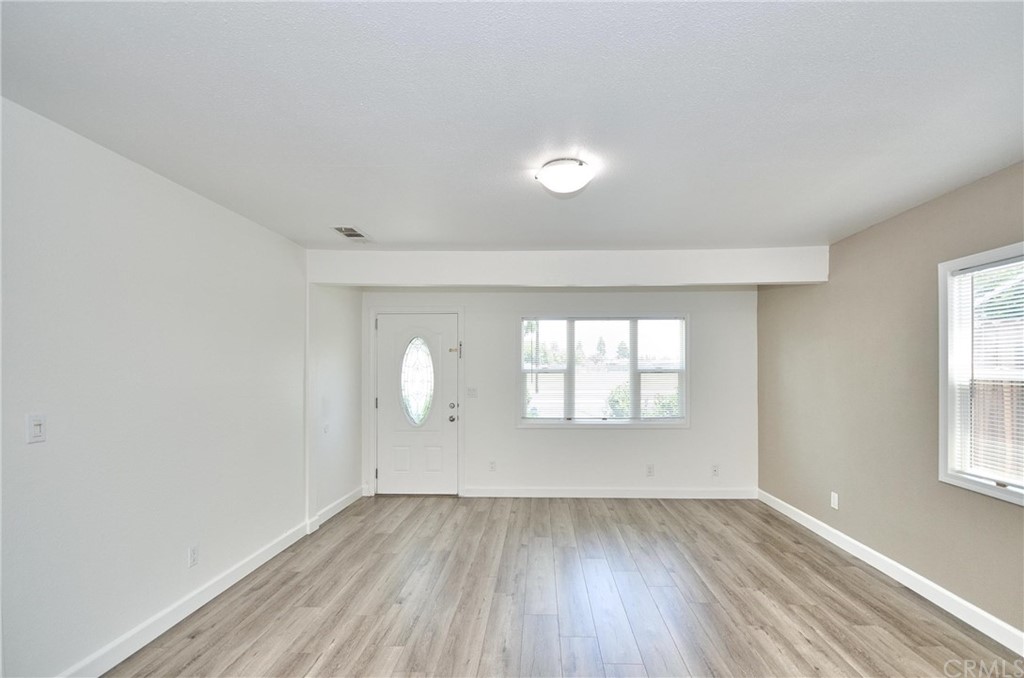 18319 Norwalk Boulevard Artesia, CA 90701 - Photo 2 of 39 an empty room with wooden floor and windows