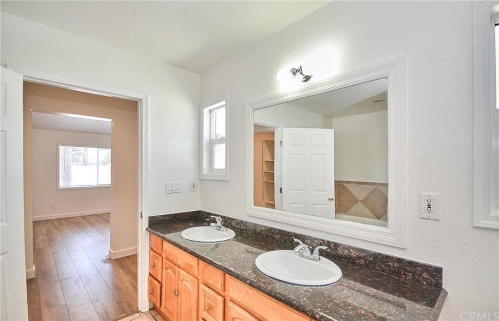 18319 Norwalk Boulevard Artesia, CA 90701 - Photo 26 of 39 a bathroom with a granite countertop sink a mirror and a shower