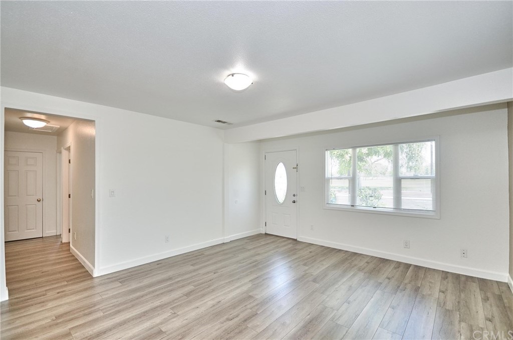 18319 Norwalk Boulevard Artesia, CA 90701 - Photo 3 of 39 an empty room with wooden floor and windows