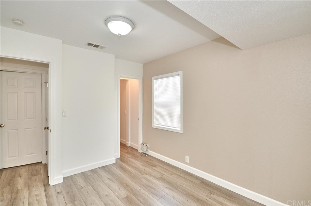 18319 Norwalk Boulevard Artesia, CA 90701 - Photo 8 of 39 an empty room with wooden floor and windows