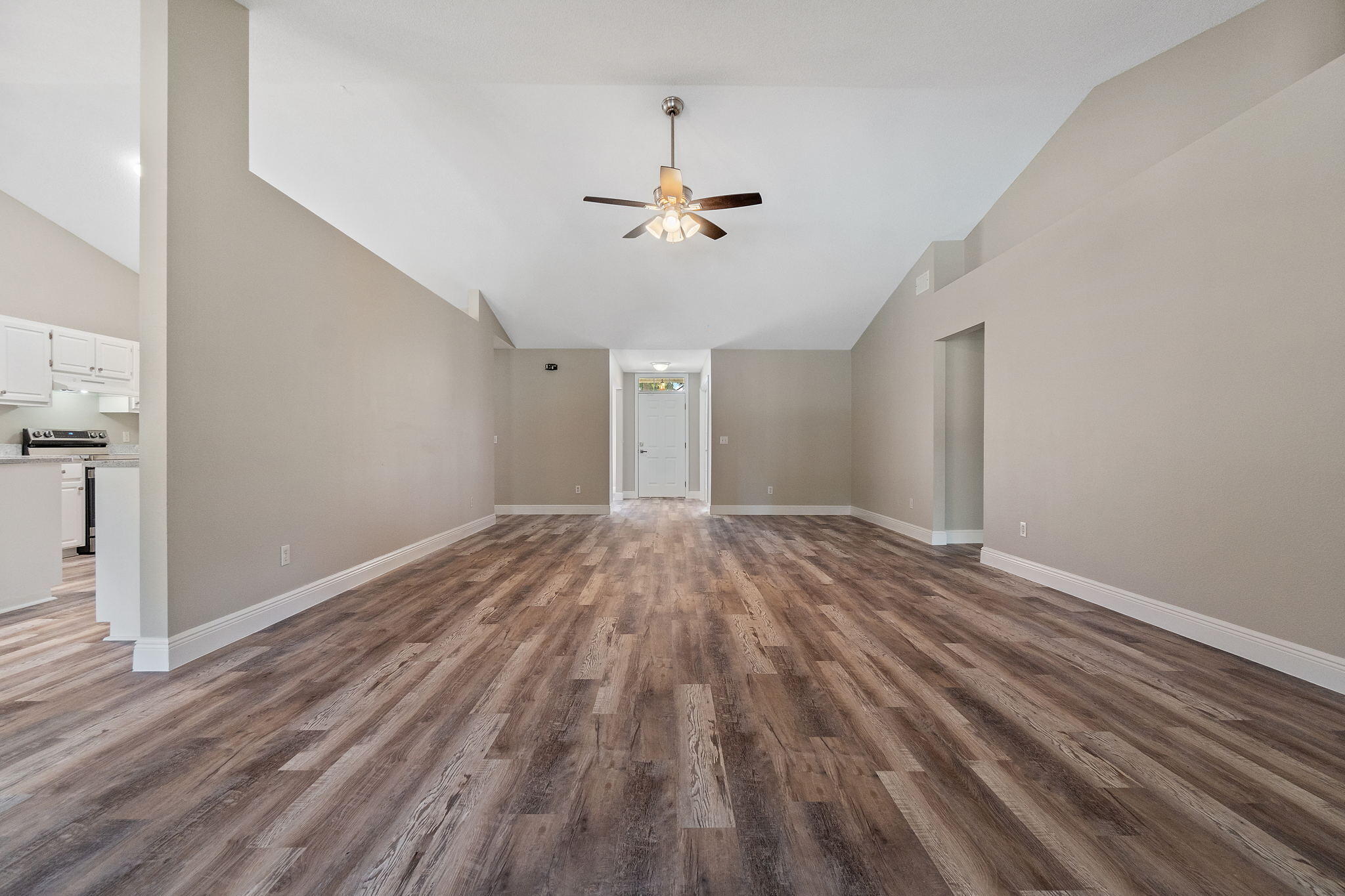 2005 Cardinal Lane Navarre, FL 32566 - Photo 14 of 63 an empty room with wooden floor ceiling fan and windows
