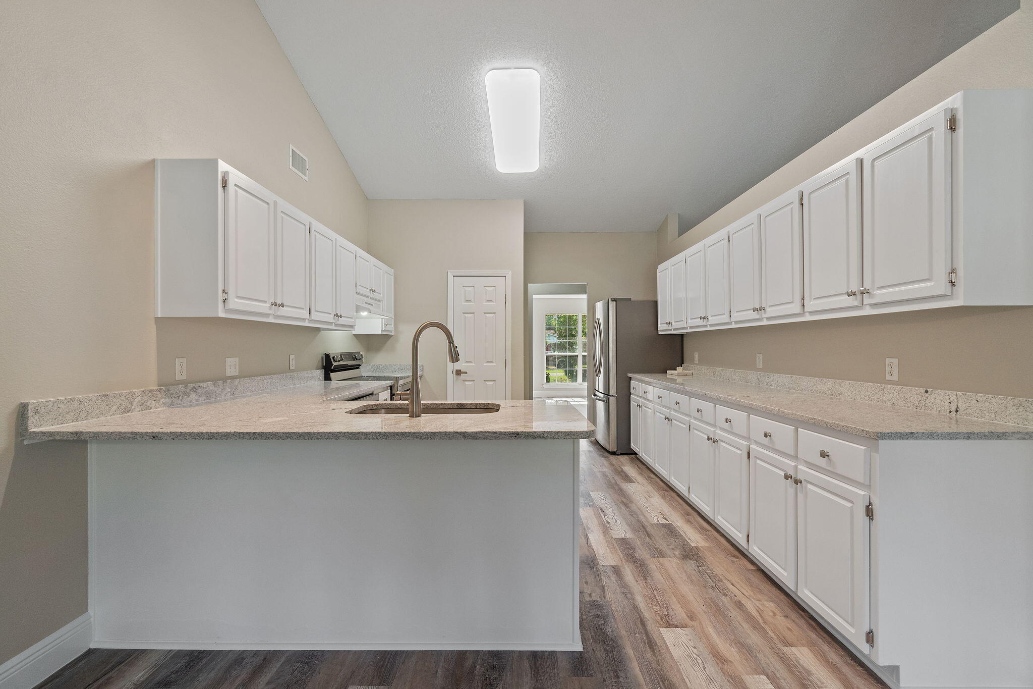 2005 Cardinal Lane Navarre, FL 32566 - Photo 18 of 63 a kitchen with stainless steel appliances granite countertop a sink a stove and white cabinets with wooden floor