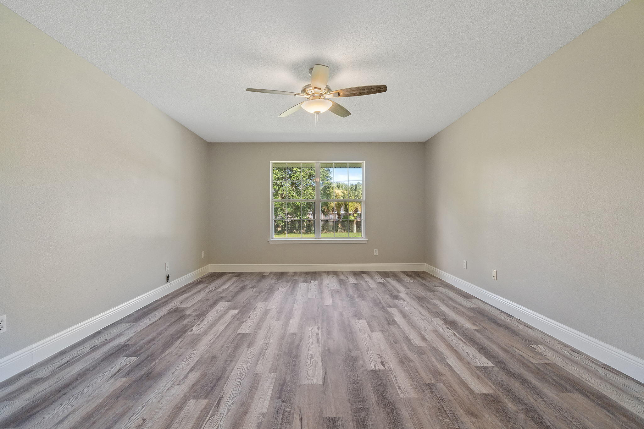 2005 Cardinal Lane Navarre, FL 32566 - Photo 23 of 63 an empty room with wooden floor chandelier fan and windows
