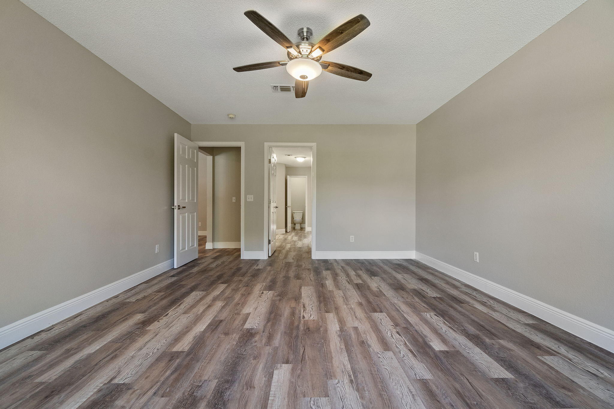 2005 Cardinal Lane Navarre, FL 32566 - Photo 25 of 63 an empty room with wooden floor and a ceiling fan