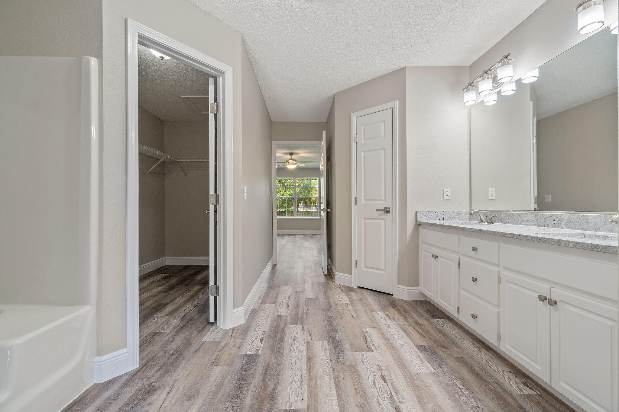 2005 Cardinal Lane Navarre, FL 32566 - Photo 29 of 63 a spacious bathroom with a granite countertop sink toilet a large mirror a bathtub and shower