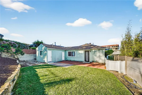 a front view of a house with a yard and potted plants