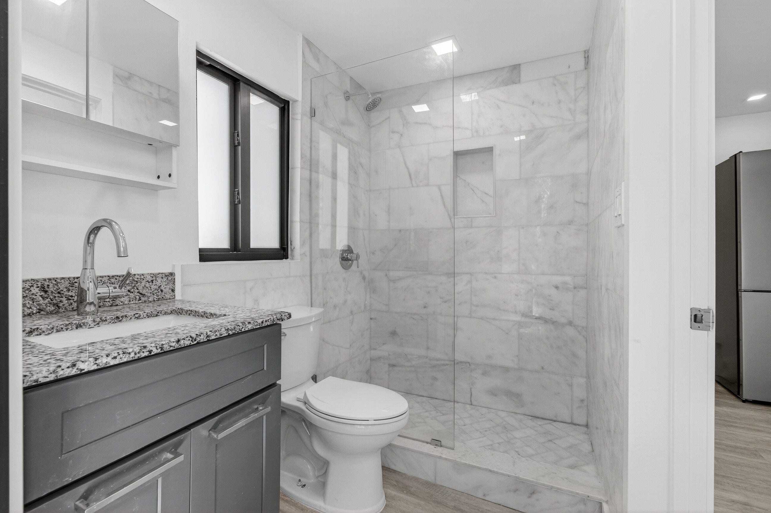 515 Northwest 1st Street, Unit 1 Delray Beach, FL 33444 - Photo 11 of 35 a bathroom with a granite countertop sink a toilet and a shower