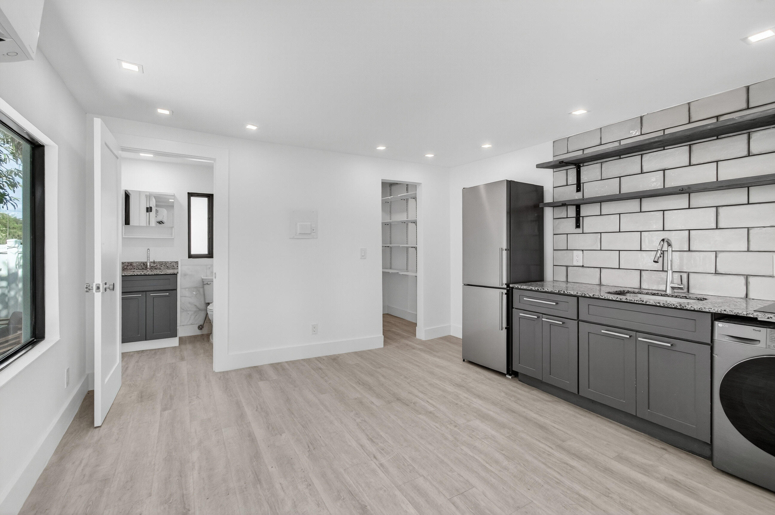 515 Northwest 1st Street, Unit 1 Delray Beach, FL 33444 - Photo 4 of 35 a kitchen with stainless steel appliances kitchen island granite countertop a refrigerator and a sink