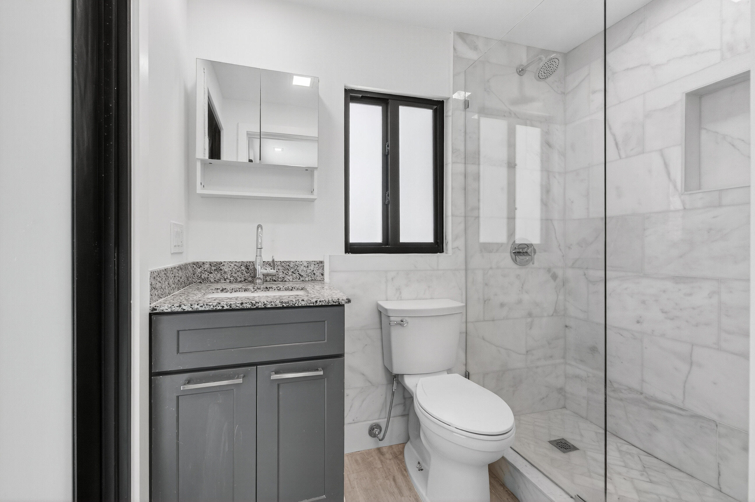 515 Northwest 1st Street, Unit 1 Delray Beach, FL 33444 - Photo 10 of 35 a bathroom with a granite countertop toilet a sink and a mirror