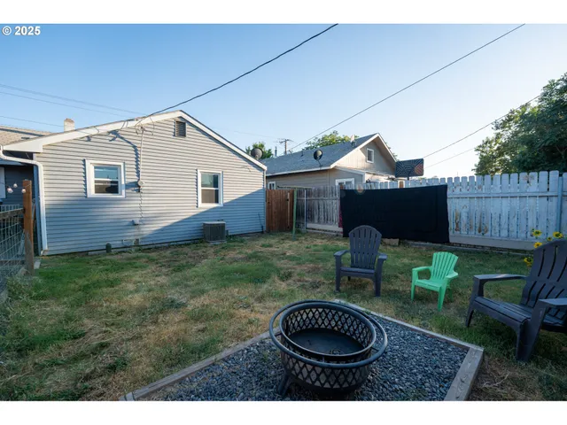 a view of a house with backyard and furniture