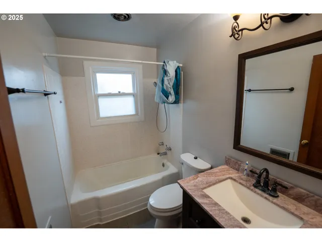 a bathroom with a granite countertop toilet sink and mirror