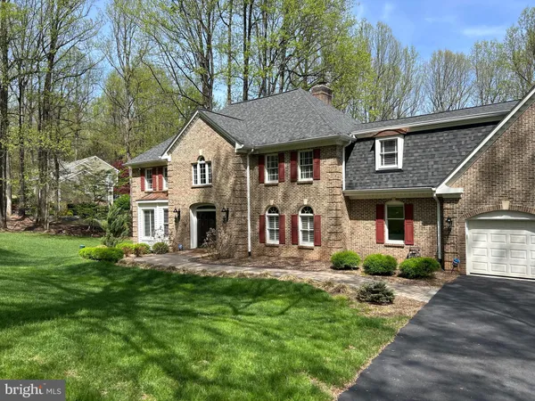 a front view of a house with a garden and trees