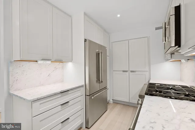 a kitchen with a refrigerator and a stove top oven