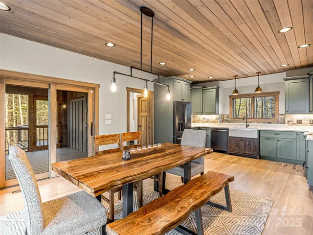 a dining hall with stainless steel appliances kitchen island granite countertop a dining table and chairs