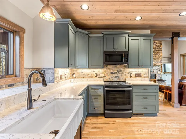 a kitchen with stainless steel appliances granite countertop a sink and a stove