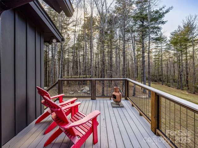 a balcony with wooden floor and trees in front of it