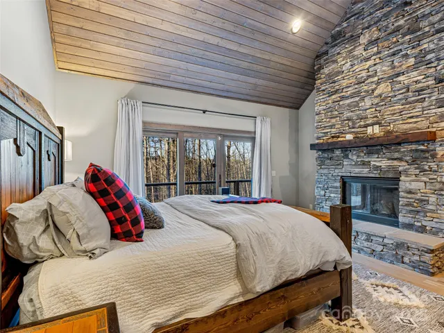 a bed sitting in a bedroom next to a fireplace with a balcony