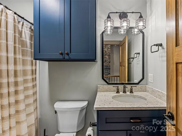 a bathroom with a granite countertop sink a toilet and a mirror