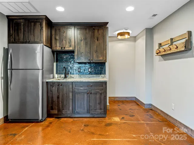 a kitchen with stainless steel appliances granite countertop a refrigerator and a sink