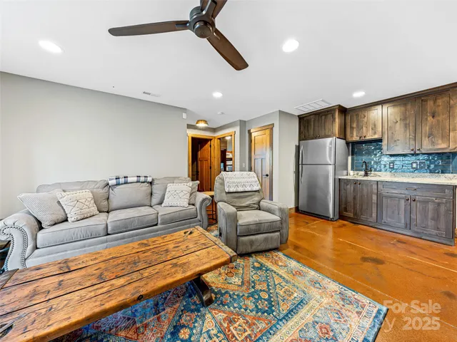 a living room with stainless steel appliances furniture and a rug