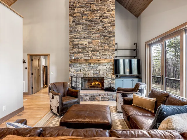 a living room with furniture fireplace and a large window