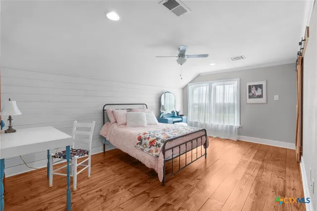 a bedroom with a bed and wooden floor