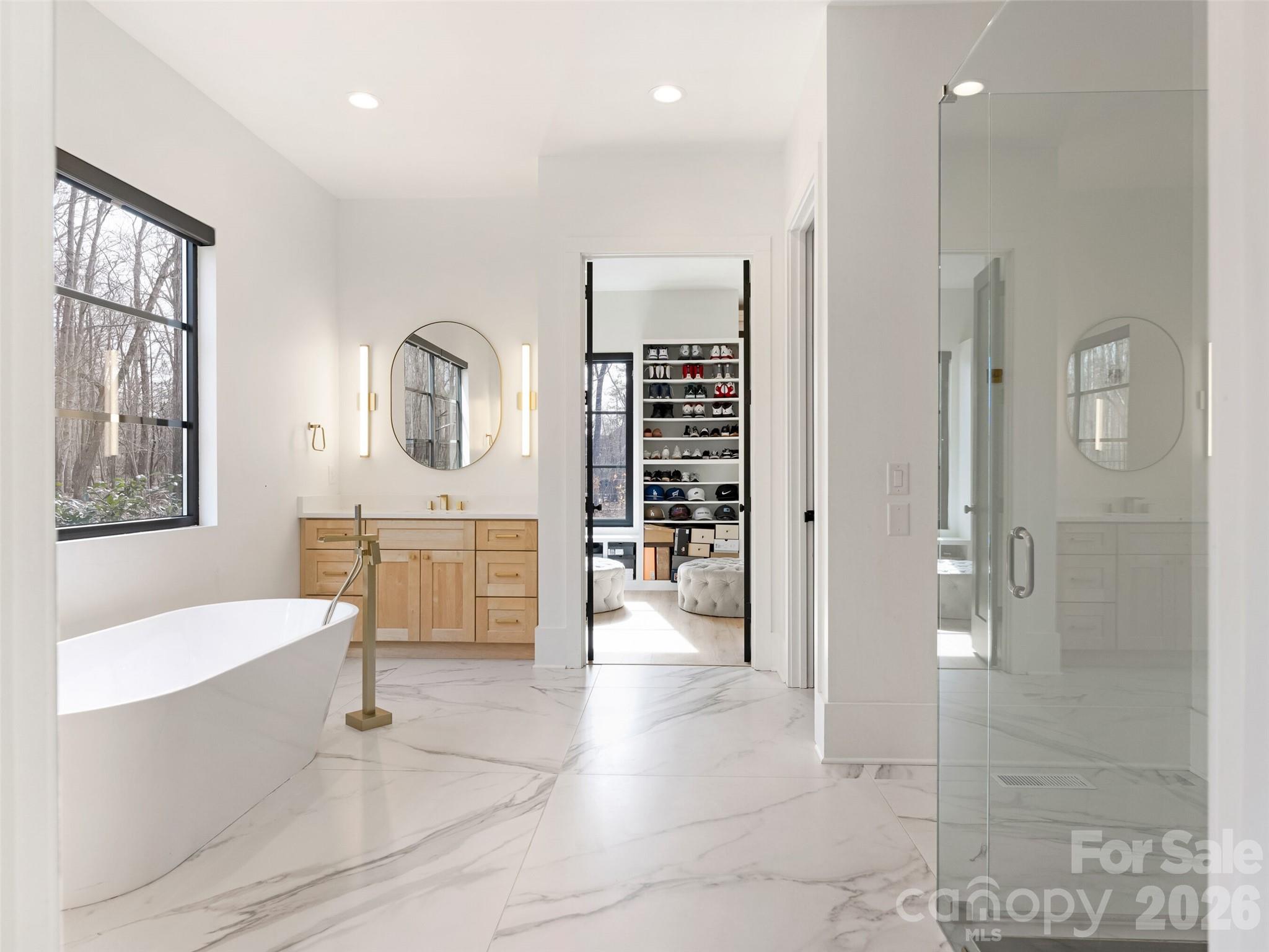 6017 Oxfordshire Road Waxhaw, NC 28173 - Photo 21 of 48 a spacious bathroom with a double vanity sink a mirror and a bathtub