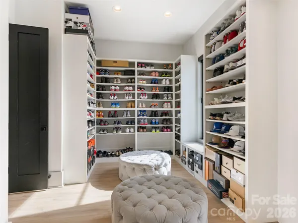 a view of walk in closet with clothes and shoes