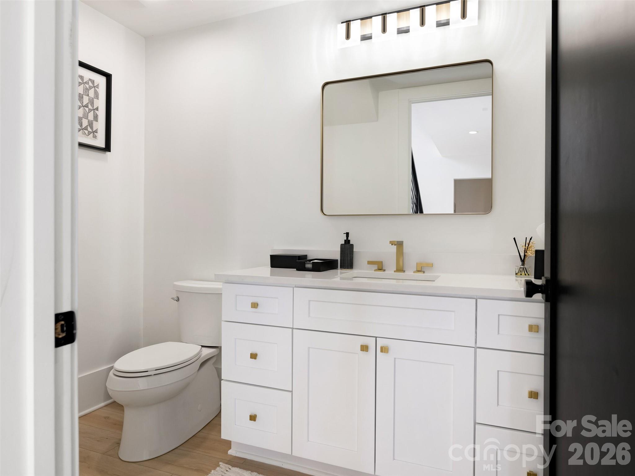 6017 Oxfordshire Road Waxhaw, NC 28173 - Photo 26 of 48 a bathroom with a toilet sink vanity and mirror