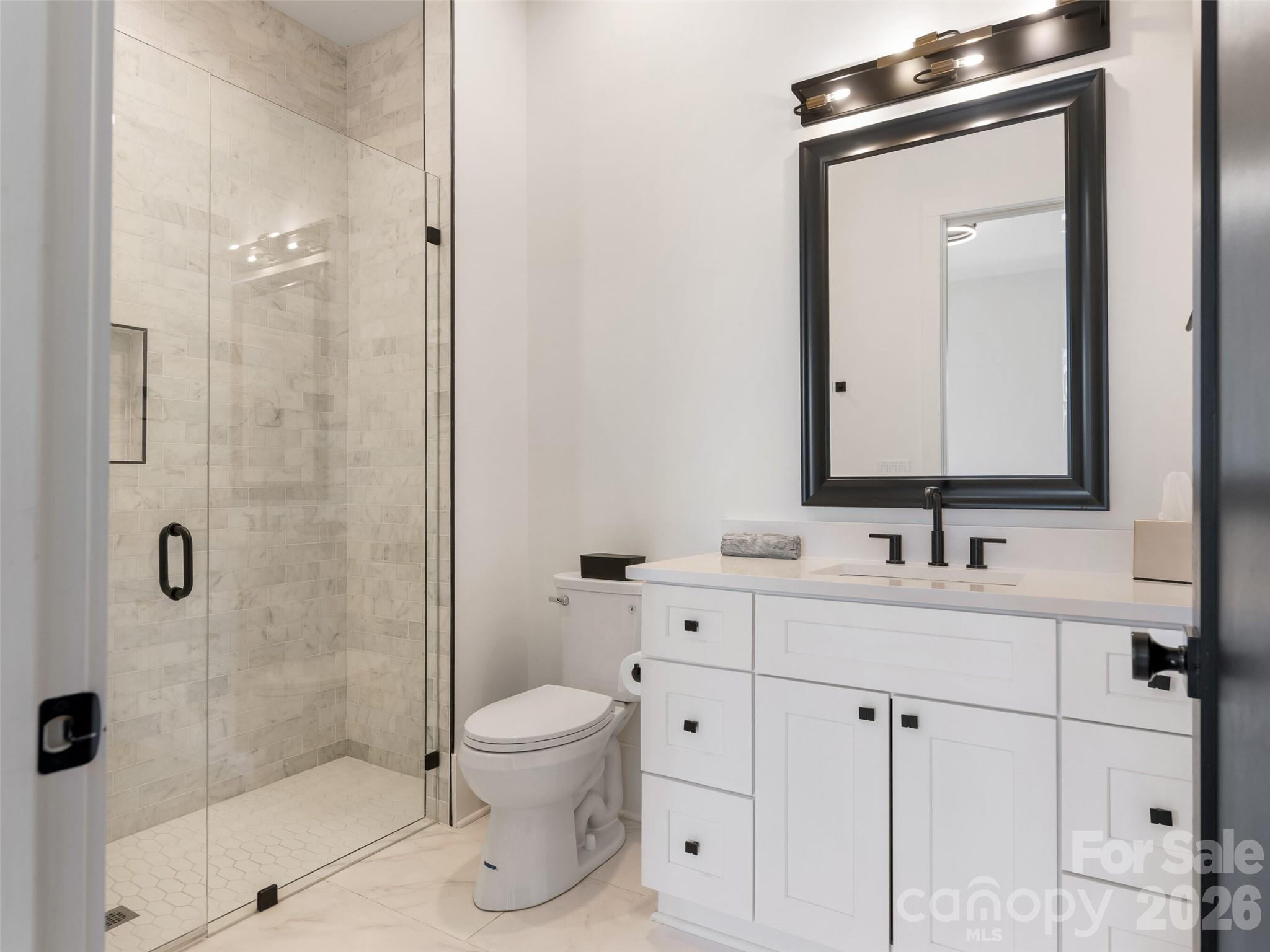 6017 Oxfordshire Road Waxhaw, NC 28173 - Photo 28 of 48 a bathroom with a toilet sink shower and mirror