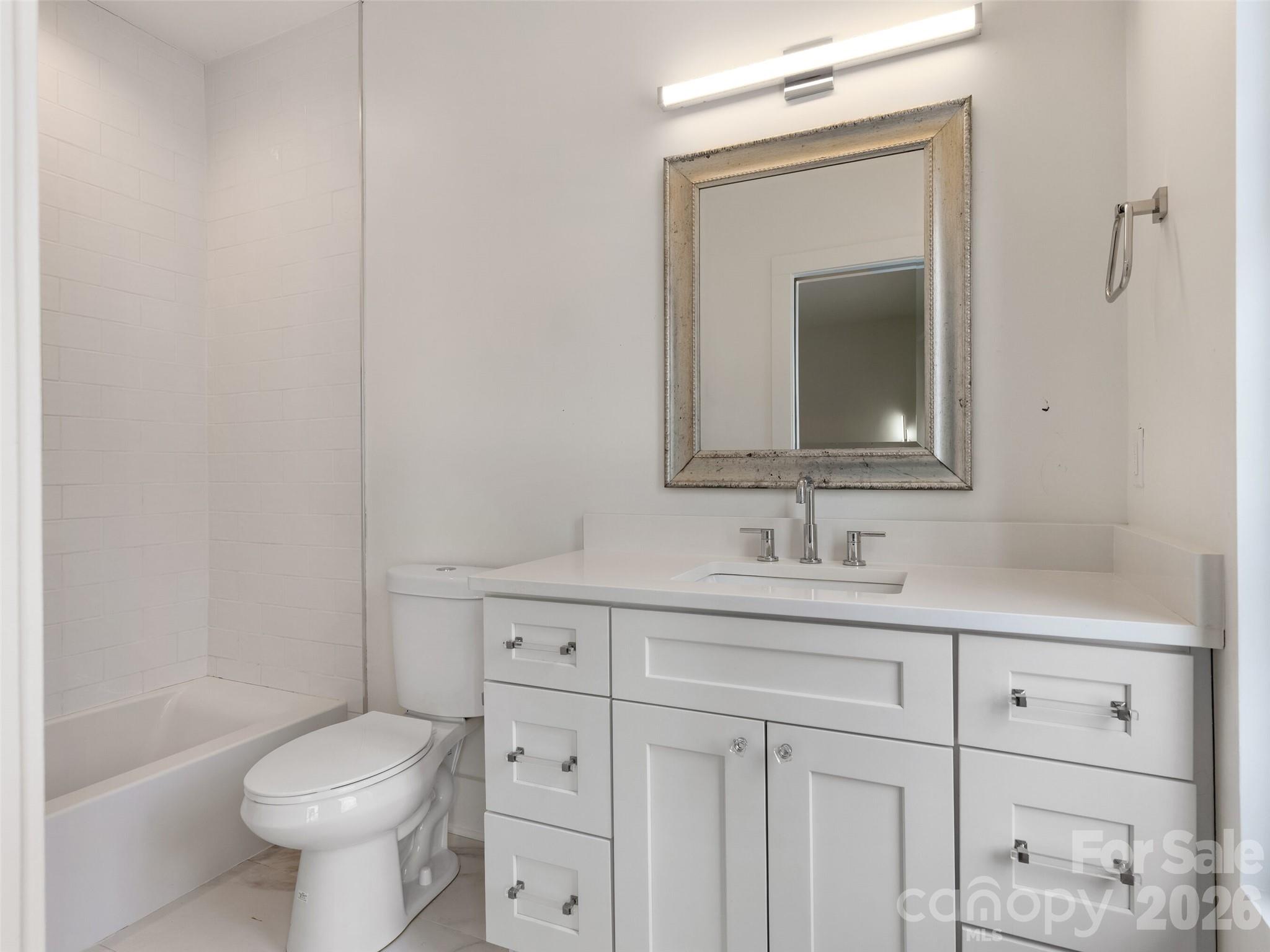 6017 Oxfordshire Road Waxhaw, NC 28173 - Photo 36 of 48 a bathroom with a toilet sink vanity and mirror